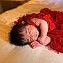 baby, newborn, sleeping, red_dress, flower_headband, bed, soft_lighting, peaceful, infant, portrait, indoors, cozy, cute, child, resting, tender, closeup, human, skin, face