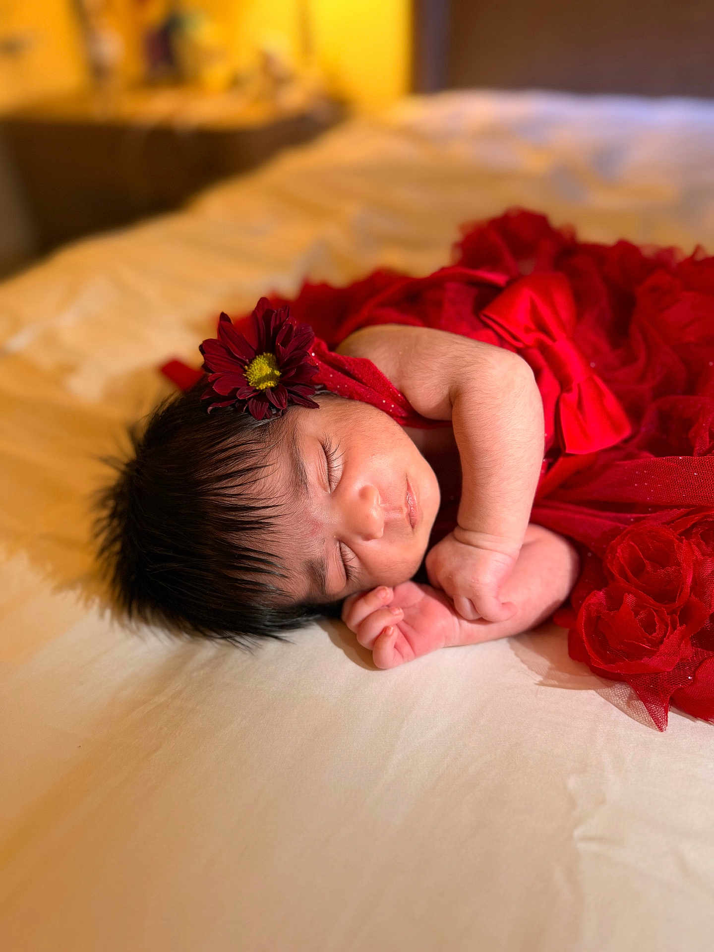 Gia joined the competition — help win amazing prizes! baby, newborn, sleeping, red_dress, flower_headband, bed, soft_lighting, peaceful, infant, portrait, indoors, cozy, cute, child, resting, tender, closeup, human, skin, face