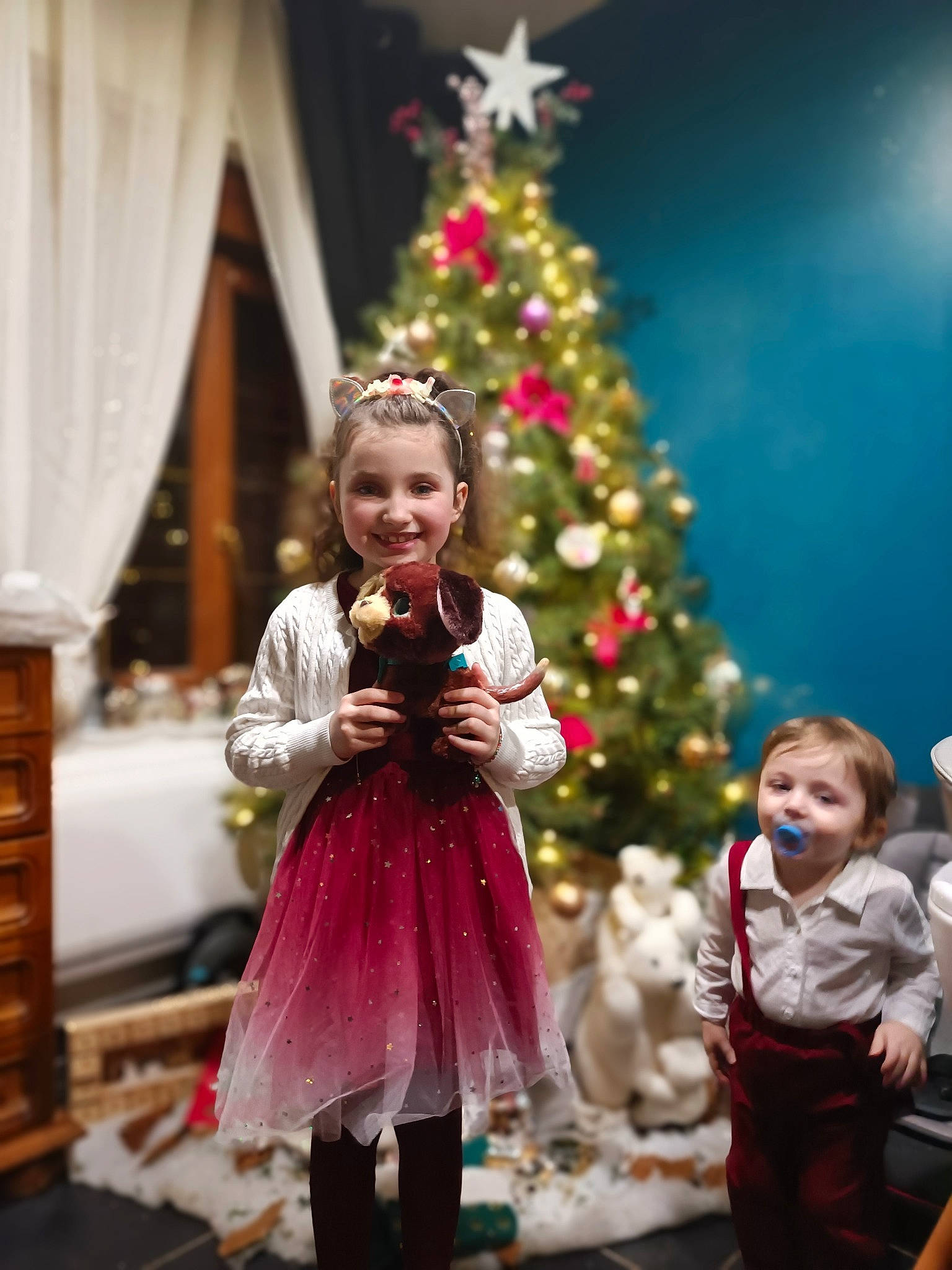 Barbara a rejoint le concours — aidez-le/la à gagner de superbes lots ! cabinetry, child, christmas_decoration, christmas_ornament, christmas_tree, curtain, drawer, entertainment, event, fashion, fun, happy, joy, ornament, performing_arts, person, plant, smile, standing, toddler