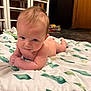 baby, infant, blanket, indoor, floor, wooden_furniture, curious, lying_down, skin, head, arms, eyes, expression, young_child, toddler, soft_texture, home, crawling_position, carpet, room