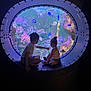 Yzhéa participe au concours pour gagner de l'argent avec cette photo : aquarium, blue, child, children, coral, curiosity, dark, exploration, fish, glass, indoor, marine_life, metal, nature, porthole, purple, seated, silhouette, underwater, window