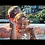 child, adult, water, splash, smile, outdoor, pool, play, sunlight, happy, parent, face, summer, recreation, water_droplets, fun, backyard, person, family, skin