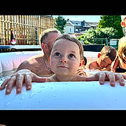 Yzhéa participe au concours pour gagner de l'argent avec cette photo : child, toddler, pool, water, summer, outdoor, sunlight, people, family, fun, play, happy, swimming, backyard, adult, relaxation, splash, skin, head, fence