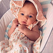 Nevaeh is registered to the contest to win money with this photo: baby, infant, blue_eyes, hat, dress, peach_pattern, bassinet, blanket, cute, child, sleeping_area, soft, clothing, portrait, newborn, resting, indoors, comfort, toddler, adorable