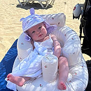 Lana joined the competition — help win amazing prizes! baby, beach, inflatable_chair, hat, blanket, sunlight, sand, ocean, umbrella, towel, foot, child, outdoor, summer, vacation, relaxation, shade, person, cute, plush