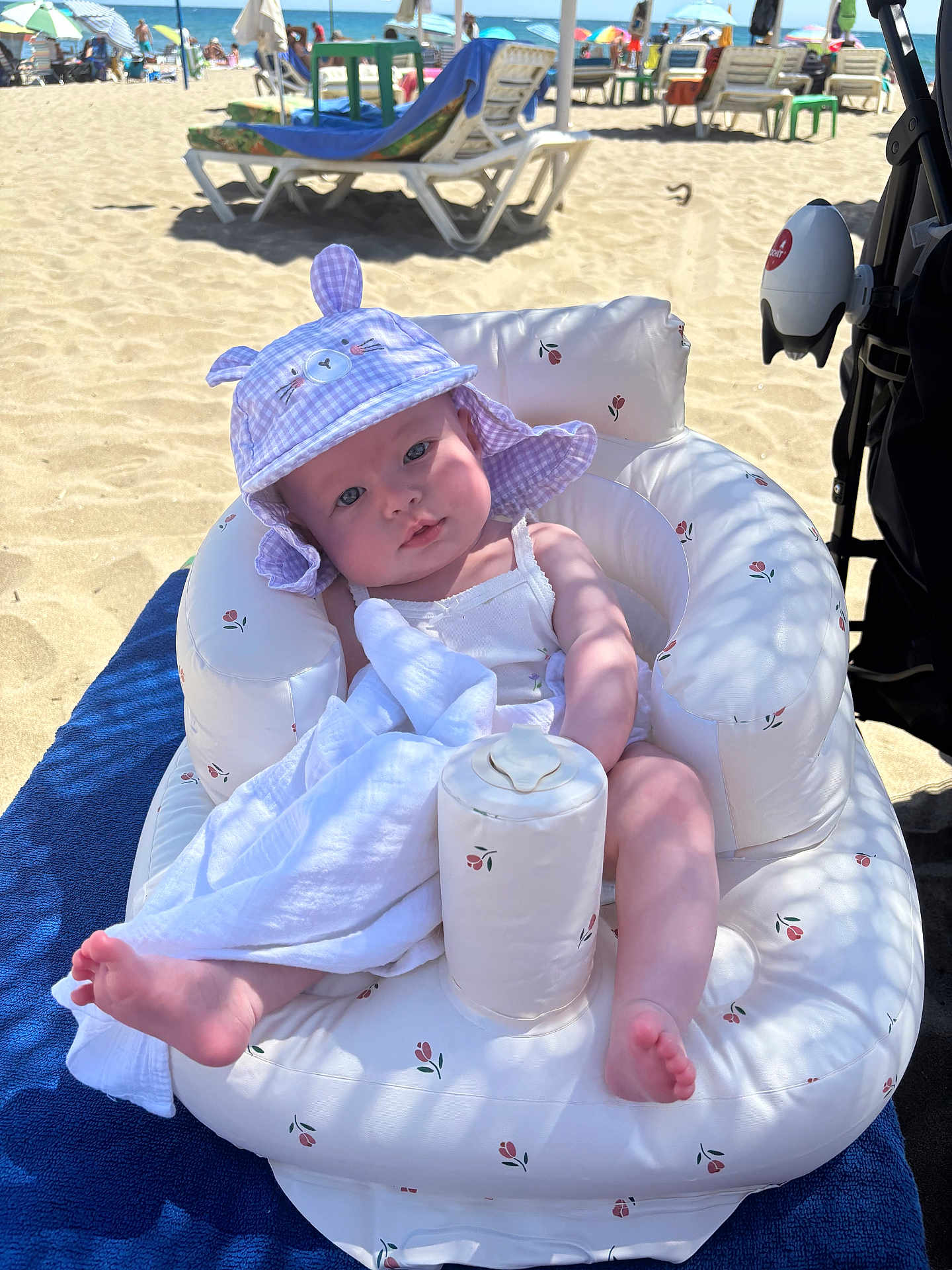 Lana joined the competition — help win amazing prizes! baby, beach, inflatable_chair, hat, blanket, sunlight, sand, ocean, umbrella, towel, foot, child, outdoor, summer, vacation, relaxation, shade, person, cute, plush