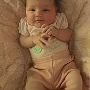 Presley is registered to the contest to win money with this photo: baby, infant, blanket, pink, clothing, cute, hands, face, lying_down, soft_texture, toddler, portrait, smile, warm, cozy, child, person, indoors, relaxing, young