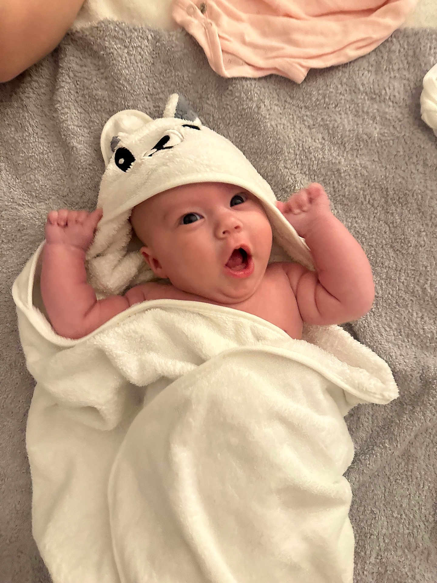 June participe au concours pour gagner de l'argent avec cette photo : baby, towel, hood, surprised, expression, blanket, infant, cute, skin, arms, face, lying_down, soft_texture, white, gray, indoors, child, wrapped, newborn, happy