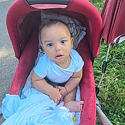 Adonaï participe au concours pour gagner de l'argent avec cette photo : baby, stroller, blanket, outdoor, grass, sidewalk, child, infant, cute, curious, person, seated, clothing, foot, hand, red, blue, nature, daylight, portrait