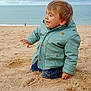 toddler, child, beach, sand, ocean, sky, cloudy, jacket, green_jacket, kneeling, play, outdoor, water, sea, nature, casual_clothing, happy, young_child, smiling, daytime