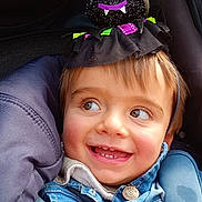 Jules a rejoint le concours — aidez-le/la à gagner de superbes lots ! toddler, child, smile, denim_jacket, stroller, headband, toy, happy, cute, face, hands, clothing, baby, portrait, outdoor, baby_carrier, seatbelt, playful, expression, accessory