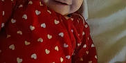 Charlotte participe au concours pour gagner de l'argent avec cette photo : baby, blanket, child, closeup, cozy, cute, face, happy, heart_pattern, indoors, infant, lying_down, onesie, person, portrait, red_clothing, smile, soft, warm_lighting, young_child