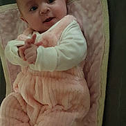 Charlotte participe au concours pour gagner de l'argent avec cette photo : baby, blanket, child, comfortable, cozy, curious, cute, face, hands, indoors, infant, lying_down, person, pink_outfit, smile, soft_texture, striped_socks, warm, white_sleeves, young