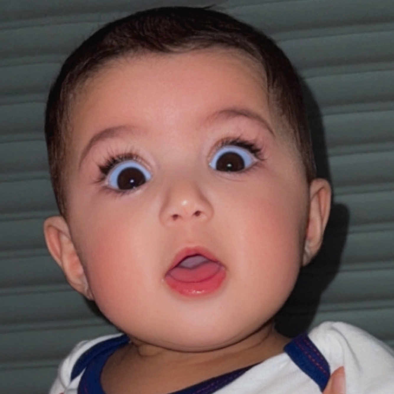 Delya participe au concours pour gagner de l'argent avec cette photo : baby, child, face, expression, wide_eyes, surprised, mouth_open, portrait, close_up, infant, cute, skin, head, young, person, eyelashes, indoors, clothing, blue, white