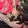 Me Me joined the competition — help win amazing prizes! cat, tabby_cat, fluffy, pet, animal, feline, fur, whiskers, lying_down, cuddling, petting, human, tattoos, arm, red_shirt, clothing, couch, remote_control, indoor, relaxed