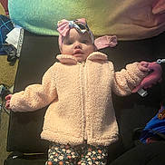 Sylvia joined the competition — help win amazing prizes! baby, infant, child, pink_jacket, floral_pants, headband, bow, toy, flamingo, blanket, indoor, carpet, clothing, cute, person, lying_down, face, wide_eyes, soft_texture, colorful