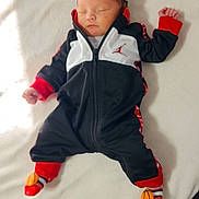 Evander joined the competition — help win amazing prizes! baby, newborn, sleeping, blanket, hat, socks, basketball, clothing, infant, cute, resting, soft, indoors, person, child, cozy, black, white, red, peaceful