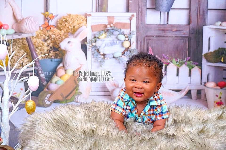 Zamari is registered to the contest to win money with this photo: baby, baby_toddler_clothing, child, event, fun, happy, houseplant, leisure, people, person, plant, purple, room, sitting, smile, snapshot, stuffed_toy, teddy_bear, toddler, toy