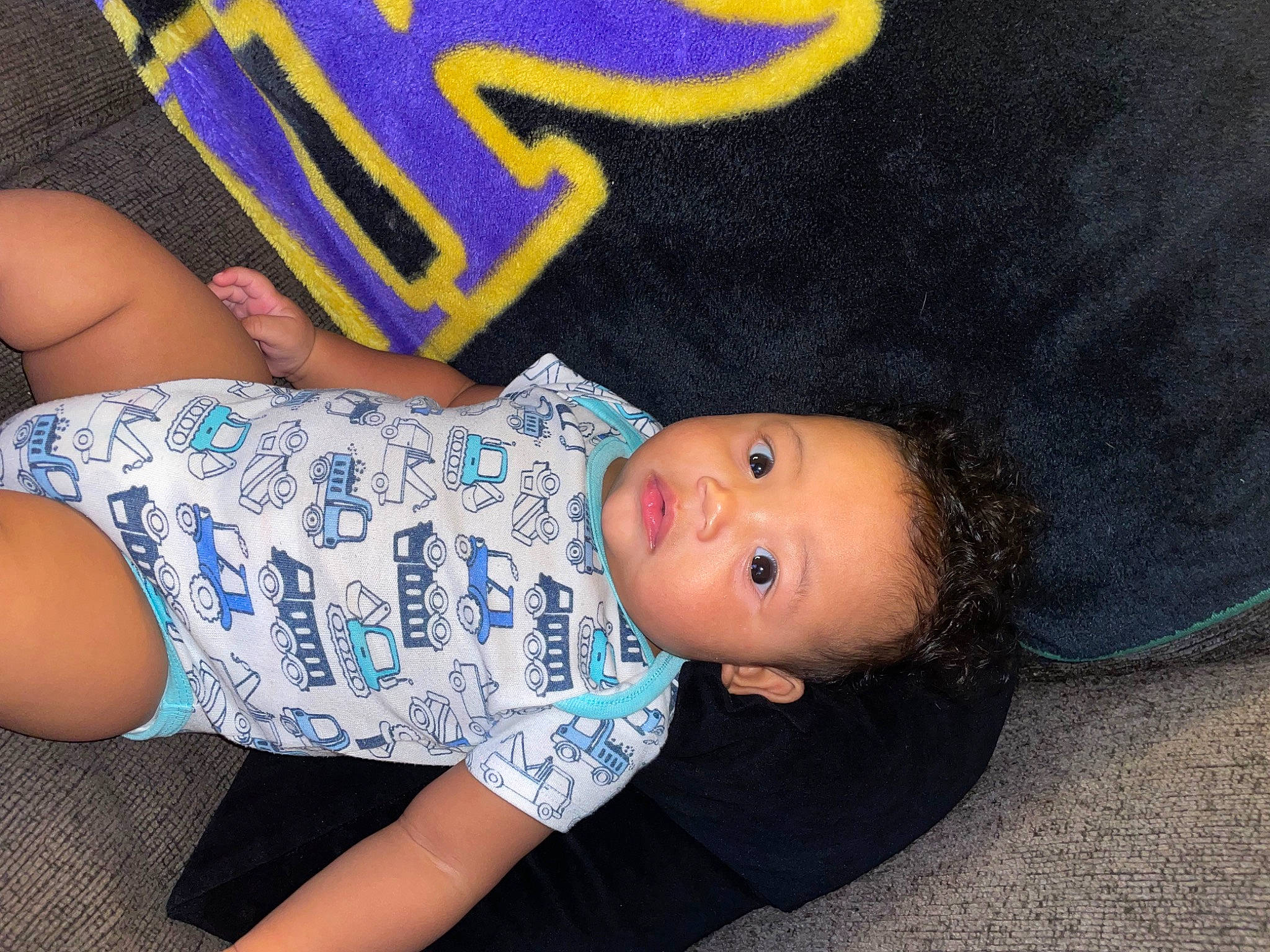 Cassius is registered to the contest to win money with this photo: baby, baby_products, baby_toddler_clothing, cheek, chest, child, comfort, elbow, electric_blue, finger, foot, happy, human_body, human_leg, leg, nail, pattern, person, sitting, thigh