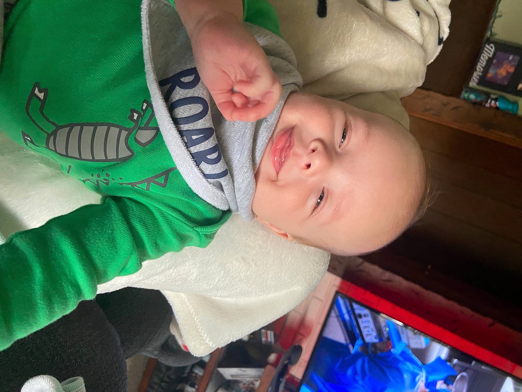 Logan joined the competition — help win amazing prizes! baby, baby_products, baby_toddler_clothing, bookcase, cheek, child, comfort, finger, fun, gesture, happy, head, mouth, people, person, sleeve, smile, t_shirt, thumb, toddler