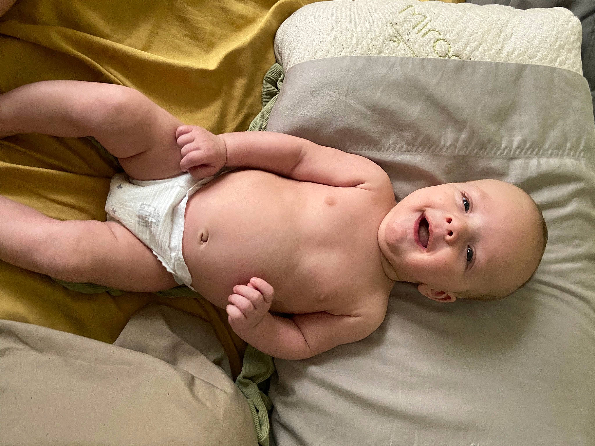 Logan is registered to the contest to win money with this photo: abdomen, baby, cheek, chest, comfort, diaper, elbow, finger, hand, head, human_body, joint, knee, mouth, muscle, person, skin, stomach, thigh, toddler
