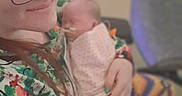 Mazikeen joined the competition — help win amazing prizes! adult, baby, blanket, chair, cozy, cuddling, family, floral_clothing, glasses, holding, indoor, infant, newborn, patterned_clothing, person, photograph, portrait, seated, smiling, soft_focus