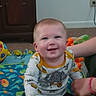 Rodney joined the competition — help win amazing prizes! baby, child, indoor, play_mat, toys, dinosaur_shirt, smiling, person, floor, carpet, hand, adult, colorful, happy, cute, infant, room, plush_toy, wall, electrical_outlet