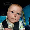 baby, child, blue_eyes, car_seat, straps, serious_expression, close_up, infant, young_child, clothing, hand, seatbelt, portrait, indoor, cute, face, skin, head, person, sitting