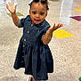 toddler, child, denim_dress, indoor, floor_tiles, vending_machine, playful, smiling, sandals, bracelets, curly_hair, person, young_child, colorful_floor, bright_lighting, open_arms, cute, casual_clothing, happy, retail_space