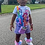 toddler, child, street, suburban, grass, house, sidewalk, sneakers, shorts, tshirt, cartoon, hair_bow, purse, playful, earrings, bracelet, watch, outdoor, daytime, person