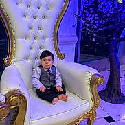 Sayed Emaan is registered to the contest to win money with this photo: barefoot, blue_lighting, chair, child, cute, decorative_tree, formal_clothing, gold, indoor, luxury, marble_floor, ornate, person, portrait, smile, throne, tie, toddler, vest, white