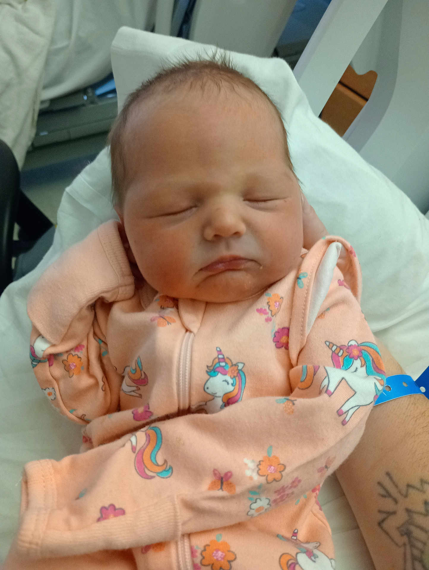Esther Leeann Taylor is registered to the contest to win money with this photo: newborn, baby, sleeping, infant, pink_clothing, unicorn_pattern, hand, hospital, wristband, tattoo, blanket, cozy, cute, portrait, child, person, soft, peaceful, resting, indoors