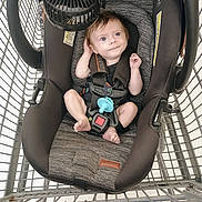 Dalton is registered to the contest to win money with this photo: baby, car_seat, shopping_cart, infant, child, seatbelt, fan, blue_pacifier, metal_cart, retail, store, cute, safety, young_child, face, expression, indoor, clothing, head_support, foot