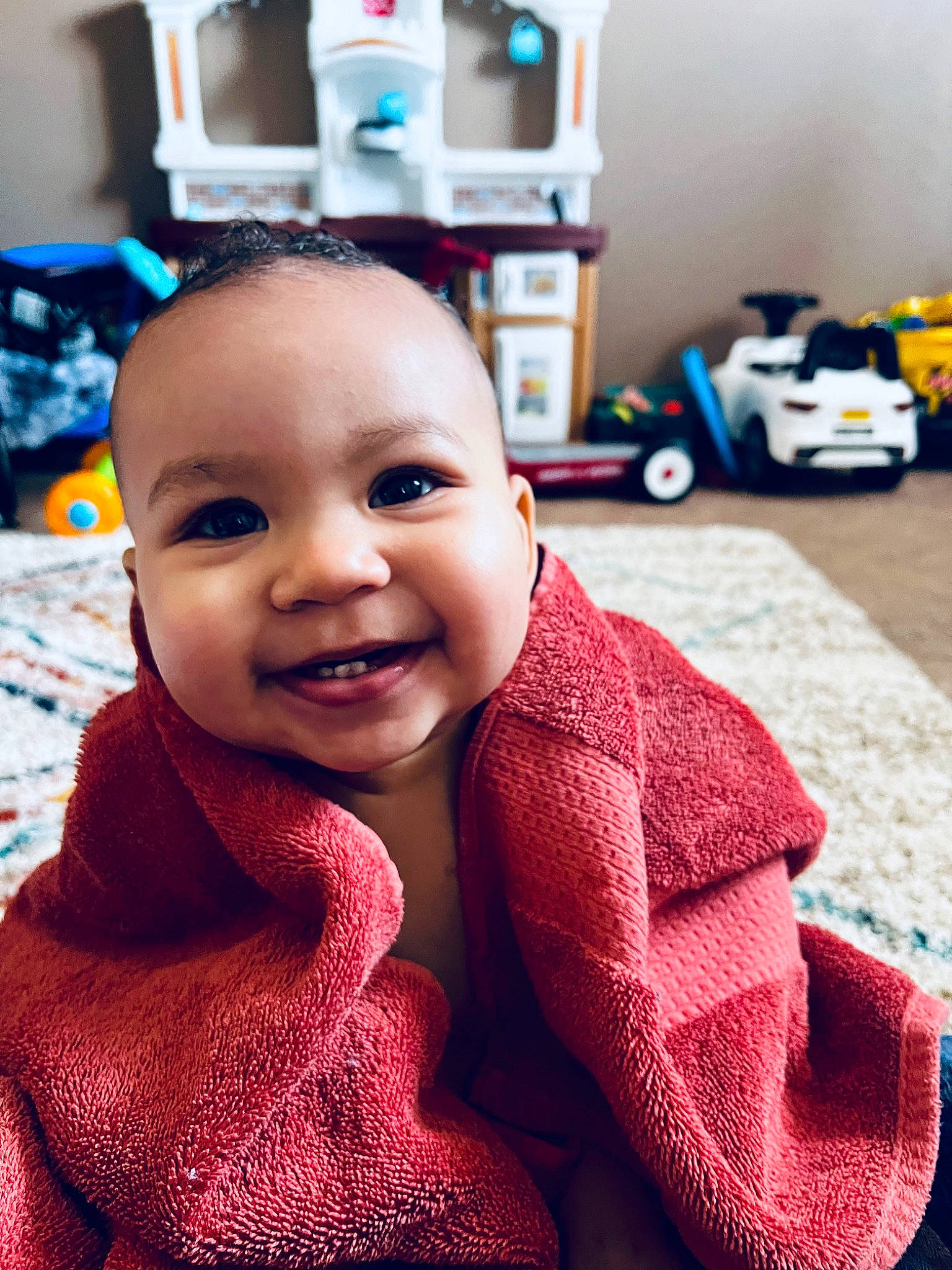 Kieran is registered to the contest to win money with this photo: baby, baby_toddler_clothing, blue, cheek, child, eye, flooring, happy, head, iris, joy, nose, pattern, person, room, sitting, skin, sleeve, smile, tire