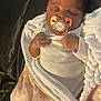 True joined the competition — help win amazing prizes! baby, sleeping, pacifier, blanket, white_clothing, pink_blanket, crown_pattern, infant, cozy, cute, child, newborn, peaceful, hands, face, resting, indoors, soft_lighting, wrapped, portrait