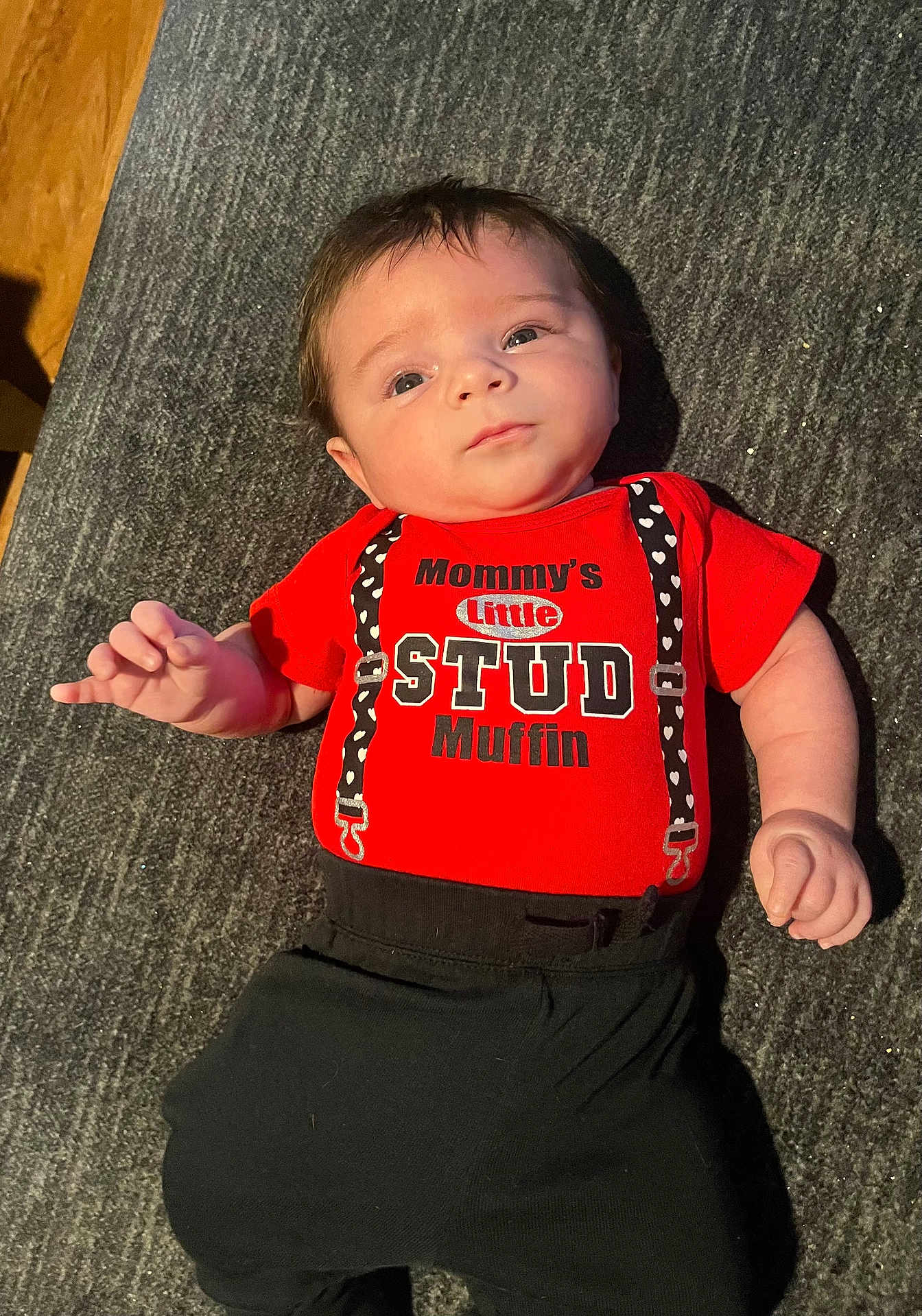 Jake joined the competition — help win amazing prizes! baby, infant, child, red_shirt, black_pants, lying_down, face, eyes, hands, cute, clothing, text_on_clothing, indoor, floor, portrait, skin, hair, expression, young, person