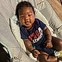 William joined the competition — help win amazing prizes! baby, child, infant, onesie, baby_seat, cushion, wood_floor, happy, smiling, cute, chubby_cheeks, relaxed, indoor, clothing, face, person, tongue, sitting, strap, comfort