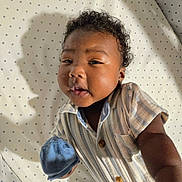 William joined the competition — help win amazing prizes! baby, child, curly_hair, striped_shirt, mittens, star_pattern, sheet, shadow, portrait, cute, infant, clothing, closeup, smiling, indoor, person, young_child, happy, face, baby_boy