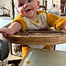 baby, high_chair, bib, kitchen, wooden_chair, messy, blue_eyes, smiling, child, person, indoor, furniture, table, clothing, feeding, happy, cute, infant, face, arm