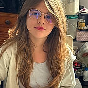 Savannah participe au concours pour gagner de l'argent avec cette photo : girl, child, glasses, long_hair, casual_clothing, indoor, kitchen, container, young_person, portrait, sitting, light, face, hair, hoodie, relaxed, person, young_female, table, background_objects