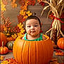 baby, pumpkin, autumn_leaves, fall, child, cute, portrait, decorations, orange, harvest, holiday, festive, smiling, indoor, seasonal, happy, person, background, wood_floor, green_clothing