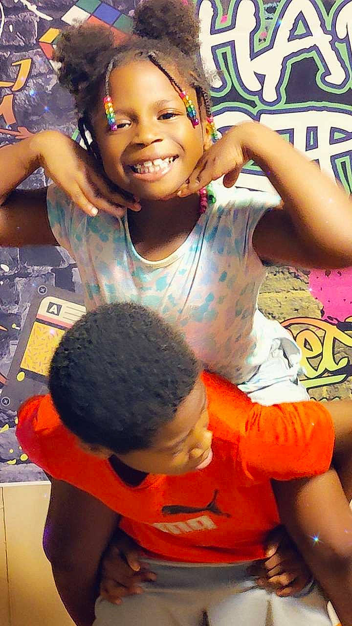 Amora is registered to the contest to win money with this photo: adaptation, black, black_hair, child, facial_expression, forehead, fun, gesture, hairstyle, happy, human, joy, leisure, mouth, organ, people, person, smile, t_shirt, thigh