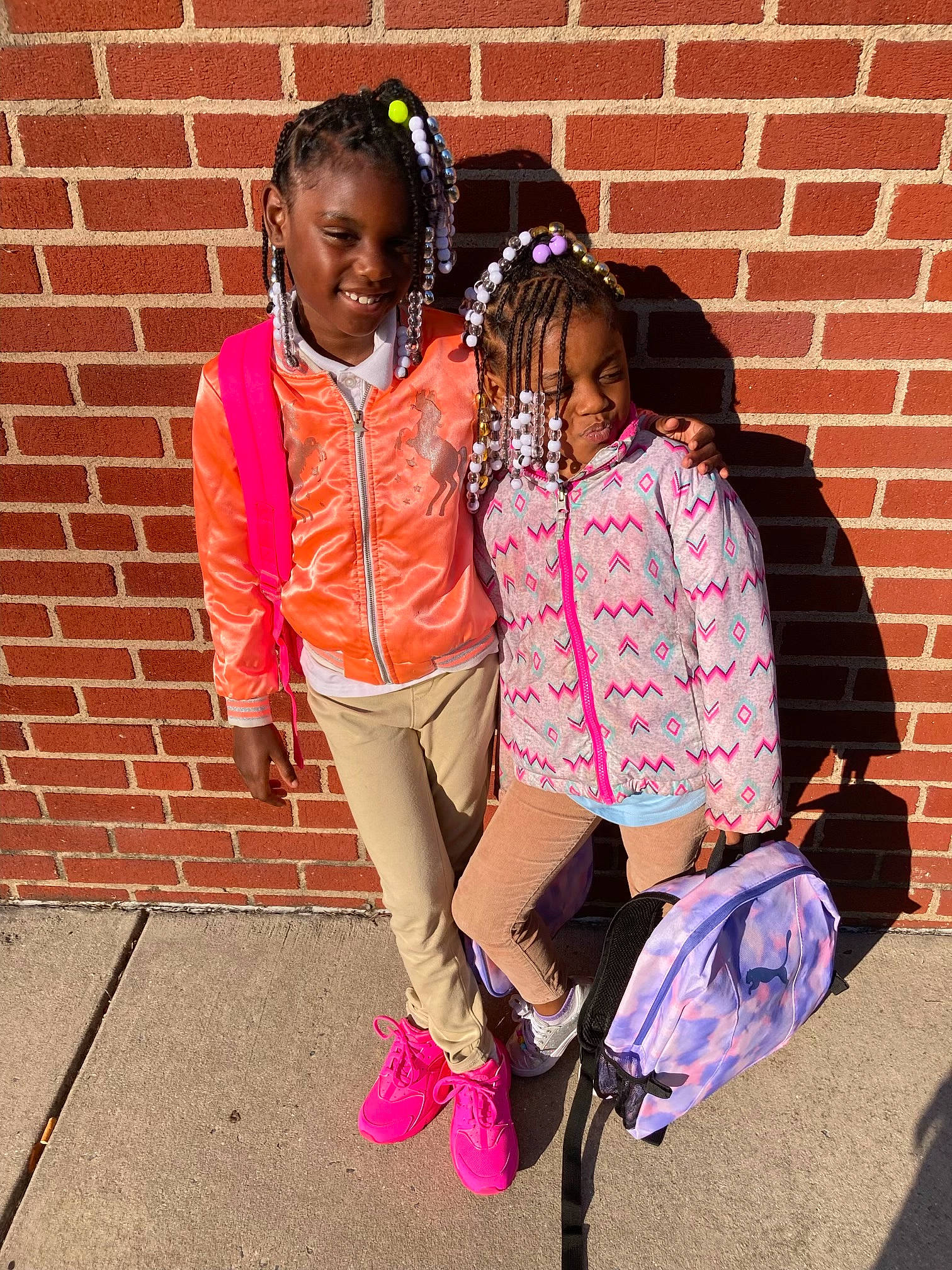 Khyasia is registered to the contest to win money with this photo: bag, brick, brickwork, child, cool, eyewear, friendship, fun, hairstyle, happy, human_leg, jewellery, joy, knee, leisure, luggage_and_bags, magenta, person, pink, smile