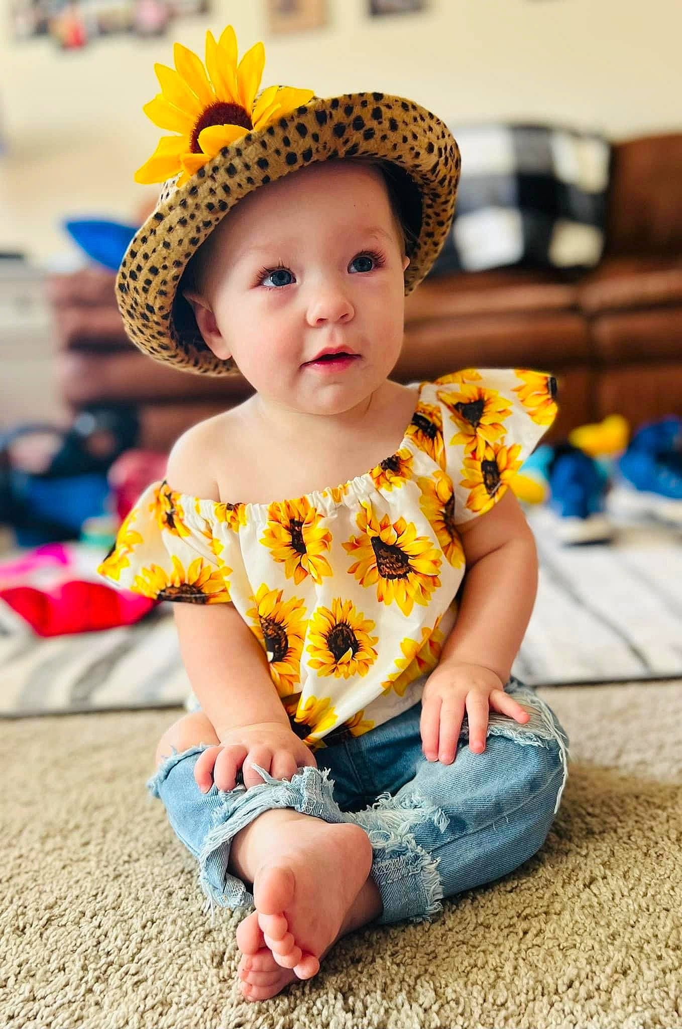 Brayleigh is registered to the contest to win money with this photo: baby_toddler_clothing, blue, cap, child, costume_hat, fashion_accessory, fun, grass, happy, hat, headwear, leisure, pattern, person, play, sitting, sleeve, street_fashion, sun_hat, t_shirt