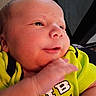 baby, newborn, infant, face, hand, clothing, yellow_shirt, expression, portrait, closeup, skin, person, cute, young, child, soft_light, indoor, newborn_clothes, baby_face, small_hand