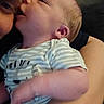 Bryson is registered to the contest to win money with this photo: baby, adult, face, arm, striped_clothing, closeup, indoor, affection, holding, person, infant, cuddle, love, skin, head, expression, family, comfort, tenderness, human