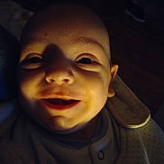 Angelo a rejoint le concours — aidez-le/la à gagner de superbes lots ! baby, smile, face, closeup, infant, dim_light, portrait, expression, child, indoors, warm_light, shadow, cute, happiness, apparel, newborn, skin, person, head, eyes