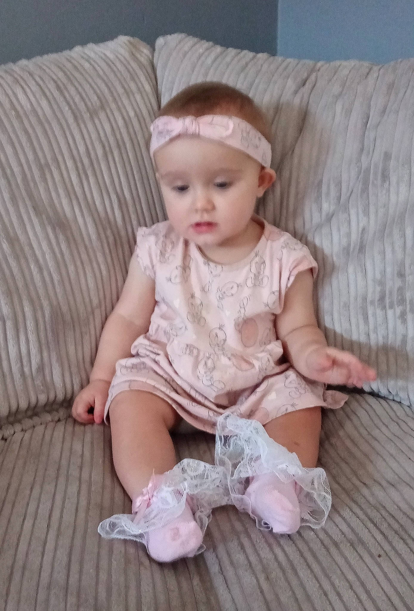 Stella-mae is registered to the contest to win money with this photo: arm, baby, baby_toddler_clothing, cheek, child, comfort, couch, embellishment, eye, face, fashion_accessory, headgear, headwear, human_leg, iris, pattern, person, pink, sleeve, textile