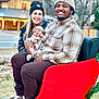 baby, baby_hat, beanie, couple, cozy, family, happy, hat, infant, jacket, man, outdoors, plaid_shirt, portrait, red_sleigh, sleigh, smile, sneakers, winter_clothing, woman