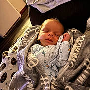 Emmitt joined the competition — help win amazing prizes! baby, blanket, bottle, closed_eyes, couch, cozy, face, furniture, hand, indoor, infant, newborn, onesie, pattern, portrait, sleeping, soft_texture, swaddle, towel, wood_floor